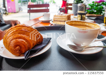 Breakfast view a bunch of croissant and a cup of coffee with cafe vibe background. Breakfast view a bunch of croissant and a cup of coffee with cafe vibe background. 115637550