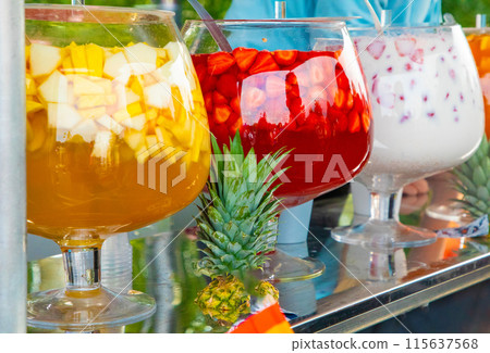 Fruit punch in large glass bowl. Drink with variety of fruits alcoholic cocktail. Fruit punch in large glass bowl. Drink with variety of fruits alcoholic cocktail. 115637568