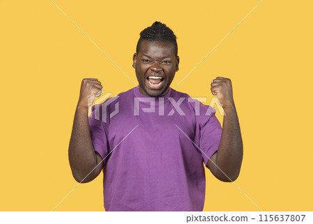 Yes, I Did It. Emotional Black Man Shaking Fists Celebrating Big Luck And Success, Looking At Camera Posing In Studio Over Yellow Background Wall. Joy Emotion, Victory Celebration Concept 115637807