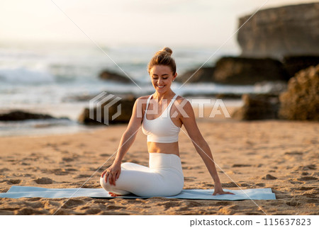 Young european lady athlete in sportswear sitting in lotus position practicing yoga, enjoying stretching body exercises on sea beach. Fit outdoor, sport and weight loss Young european lady athlete in sportswear sitting in lotus position practicing yoga, enjoying stretching body exercises on sea beach. Fit outdoor, sport and weight loss 115637823