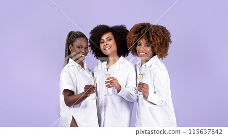 Cheers, Female Party Concept. Three Smiling Black Young Women Raising Glasses With Sparkling Wine, Toasting Looking At Camera While Celebrating Holiday On Purple Background, Studio Shot, Panorama Cheers, Female Party Concept. Three Smiling Black Young Women Raising Glasses With Sparkling Wine, Toasting Looking At Camera While Celebrating Holiday On Purple Background, Studio Shot, Panorama 115637842