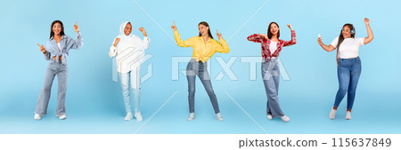 Smiling millennial diverse women in wireless headphones dancing, have fun with phone, enjoy fun, isolated on blue studio background, panorama, full length. Relax, lifestyle, ad and offer 115637849