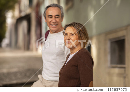 Portrait Of Senior Tourists Couple Walking Outdoors, Man Looking At His Happy Mature Wife With Love, Selective Focus On Woman. Romantic Vacation And Relationship In Older Age Concept 115637973