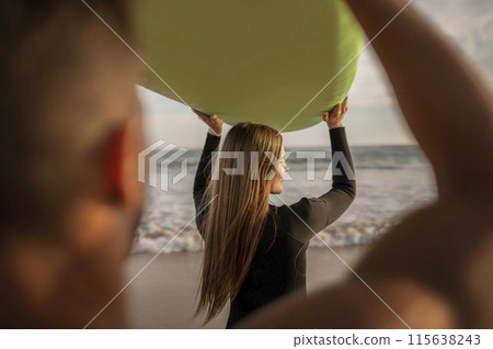 Activities For Couples. Young Man And Woman Surfing Together On The Beach, Rear View Of Millennial Couple Carrying Surfboard Above Heads While Walking On Seashore At Sunset, Enjoying Water Sports Activities For Couples. Young Man And Woman Surfing Together On The Beach, Rear View Of Millennial Couple Carrying Surfboard Above Heads While Walking On Seashore At Sunset, Enjoying Water Sports 115638243