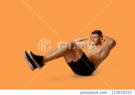 A fit young man is doing bicycle crunches against a solid orange background in a studio, showcasing his strength and fitness routine. A fit young man is doing bicycle crunches against a solid orange background in a studio, showcasing his strength and fitness routine. 115638355