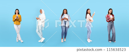 Cheerful young black, arab, asian women in casual chatting on smartphones, isolated on blue studio background, panorama, full length. Social networks, lifestyle, shopping online app Cheerful young black, arab, asian women in casual chatting on smartphones, isolated on blue studio background, panorama, full length. Social networks, lifestyle, shopping online app 115638523