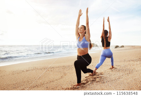 Positive young caucasian women enjoy morning workout, peace, breathing exercises together, practicing yoga on sea beach. Morning sports, lifestyle and body care, vitality outdoor 115638548
