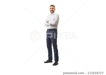 A confident businessman is standing with his arms crossed, wearing a white shirt and blue pants. He appears to be in a studio setting during daytime, smiling and exuding confidence. 115638727
