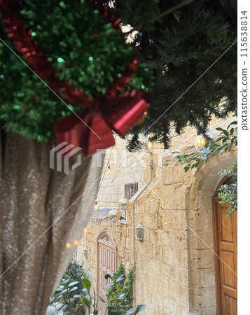 Christmas tree decorated with red ribbons and garlands in a restaurant at the Valetta street, Malta 115638814