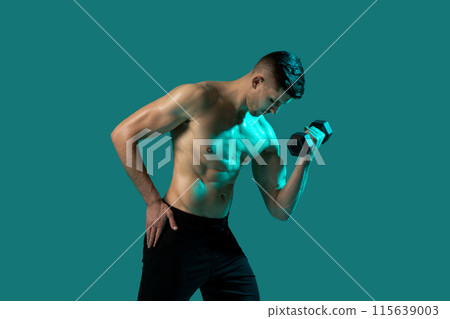 A man is lifting a dumbbell with one hand against a vibrant green background. He is focused and showing determination in his workout routine. 115639003