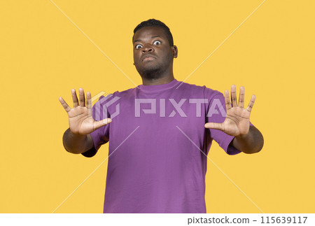 Shocked young african american man making stop gesture with hands, pushing camera back standing over yellow background in studio. Disgust, say no and negative emotion, sign of personal space Shocked young african american man making stop gesture with hands, pushing camera back standing over yellow background in studio. Disgust, say no and negative emotion, sign of personal space 115639117