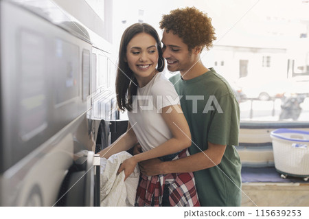 Laundry Chores. Romantic Hispanic Man Hugging Wife From Back While Loading Washing Machine At Public Laundromat Room Indoor. Couple Embracing Advertising Best Laundrette Service Laundry Chores. Romantic Hispanic Man Hugging Wife From Back While Loading Washing Machine At Public Laundromat Room Indoor. Couple Embracing Advertising Best Laundrette Service 115639253