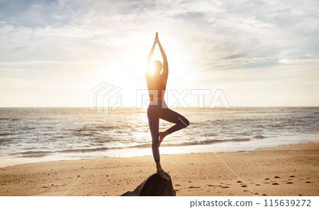 Young caucasian woman meditating, enjoy workout, peace, balance and breathing exercises, practicing yoga on sea beach, sun flare. Lifestyle, habit and health care, vitality outdoor Young caucasian woman meditating, enjoy workout, peace, balance and breathing exercises, practicing yoga on sea beach, sun flare. Lifestyle, habit and health care, vitality outdoor 115639272