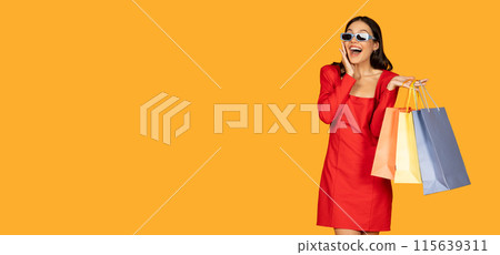 A woman dressed in a vibrant red dress stands holding multiple shopping bags in her hands, showcasing a successful shopping trip, looking at copy space A woman dressed in a vibrant red dress stands holding multiple shopping bags in her hands, showcasing a successful shopping trip, looking at copy space 115639311
