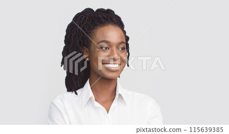 Portrait of attractive millennial black businesswoman posing on white studio background, looking at copy space, closeup 115639385