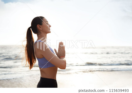 Calm glad young caucasian woman enjoy morning workout alone, silence, calm and breathing exercises, practicing yoga on sea beach. Meditation, sports, lifestyle and body care outdoor Calm glad young caucasian woman enjoy morning workout alone, silence, calm and breathing exercises, practicing yoga on sea beach. Meditation, sports, lifestyle and body care outdoor 115639493