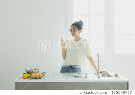 一個女人在廚房喝水 一個女人在廚房喝水 115639737