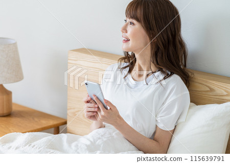 一個女人在床上放鬆。 一個女人在床上放鬆。 115639791