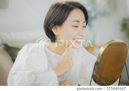 中年婦女在客廳照鏡子 中年婦女在客廳照鏡子 115640307