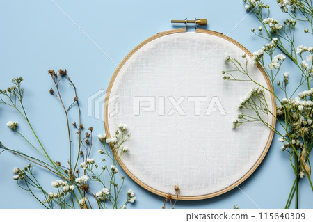 Flat lay composition with embroidery hoop and dried flowers on a light background 115640309