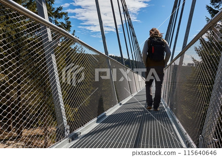 Skybridge 721 suspension footbridge, man walking through 115640646
