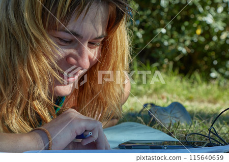 Student studying language notes in park Student studying language notes in park 115640659