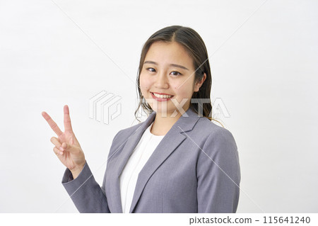 年輕女商人做和平標誌，白色背景 115641240