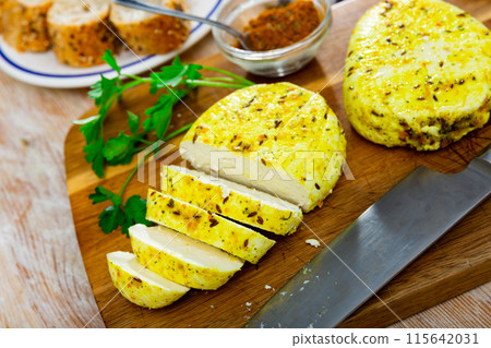 Slices of spicy roasted cottage cheese with turmeric and cumin on wooden board Slices of spicy roasted cottage cheese with turmeric and cumin on wooden board 115642031