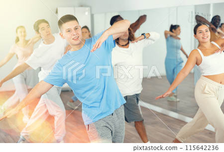 Group of different people rehearsing dance in dance studio 115642236
