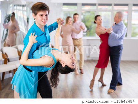 Teaching latin american dances in dance studio - people of different ages dance in pairs Teaching latin american dances in dance studio - people of different ages dance in pairs 115642494