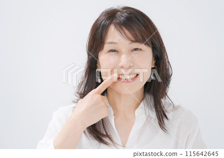 中年婦女指著她的嘴 中年婦女指著她的嘴 115642645