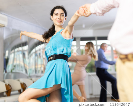 Positive pairs practicing vigorous jive movements in dance class 115642647