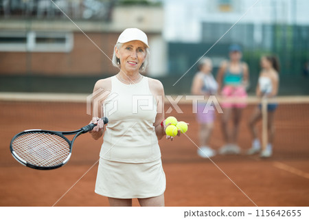 Elderly woman posing on tennis court Elderly woman posing on tennis court 115642655