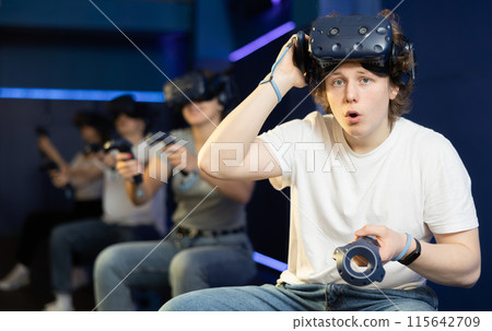 Surprised man looking at camera with enthusiastic eyes after playing virtual game Surprised man looking at camera with enthusiastic eyes after playing virtual game 115642709