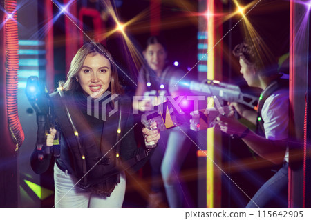 Girl running and dodging while playing lasertag Girl running and dodging while playing lasertag 115642905