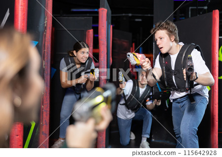 Three people playing lasertag in arena Three people playing lasertag in arena 115642928