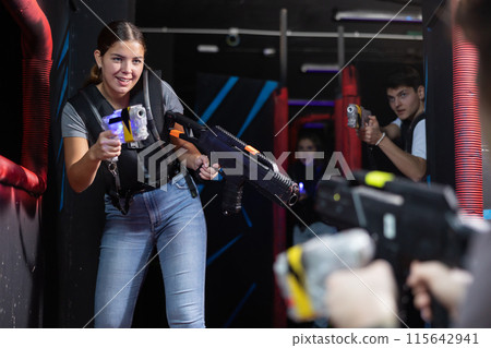 Girl running and dodging while playing lasertag Girl running and dodging while playing lasertag 115642941