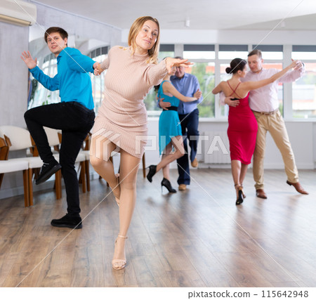 Dynamic pair engaging in Latino dance in dance studio. Pairs training ballroom dance in studio 115642948