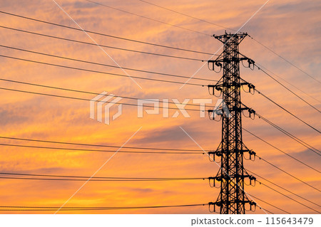 A row of power transmission towers and a thin cloudy sunset sky e-1 A row of power transmission towers and a thin cloudy sunset sky e-1 115643479