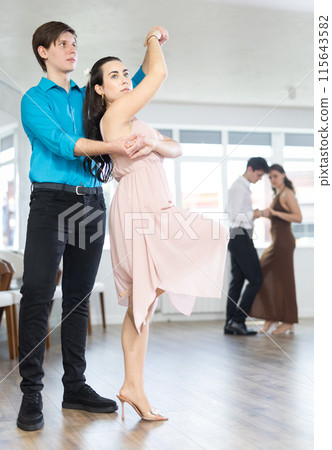 During rehearsal, guy and girl participants of dance workshop perform figure waltz During rehearsal, guy and girl participants of dance workshop perform figure waltz 115643582
