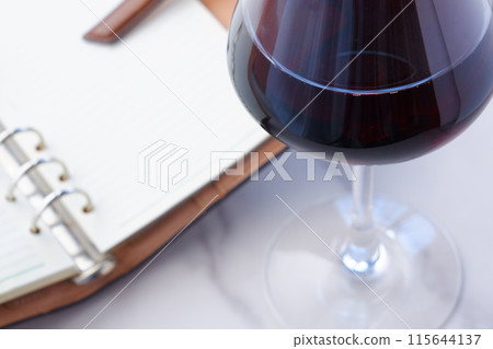 我一邊喝著紅酒一邊用環形筆記本寫日記的照片 115644137