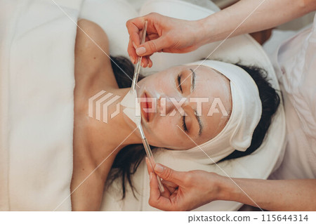 A girl at a cosmetologist does cosmetic procedures. Skin cleansing A girl at a cosmetologist does cosmetic procedures. Skin cleansing 115644314