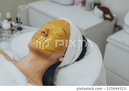 A girl at a cosmetologist does cosmetic procedures. Alginate mask A girl at a cosmetologist does cosmetic procedures. Alginate mask 115644323