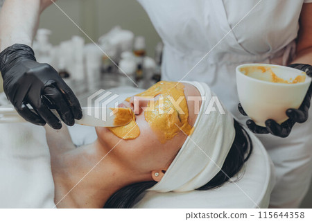 A girl at a cosmetologist does cosmetic procedures. Alginate mask A girl at a cosmetologist does cosmetic procedures. Alginate mask 115644358