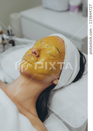 A girl at a cosmetologist does cosmetic procedures. Alginate mask A girl at a cosmetologist does cosmetic procedures. Alginate mask 115644727