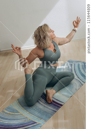 A 50-year-old woman does yoga at home A 50-year-old woman does yoga at home 115644809