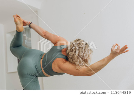 A 50-year-old woman does yoga at home A 50-year-old woman does yoga at home 115644819