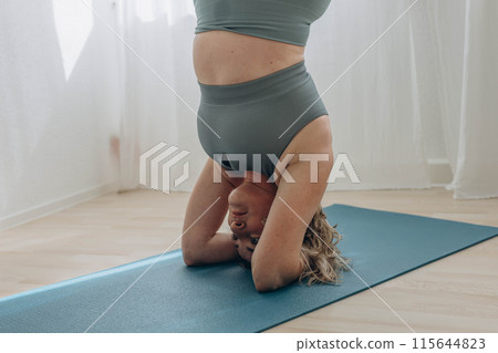 A 50-year-old woman does yoga at home A 50-year-old woman does yoga at home 115644823