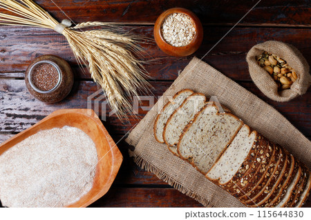 Wholemeal wheat bread or integral bread with grains and seeds sliced on wooden table 115644830