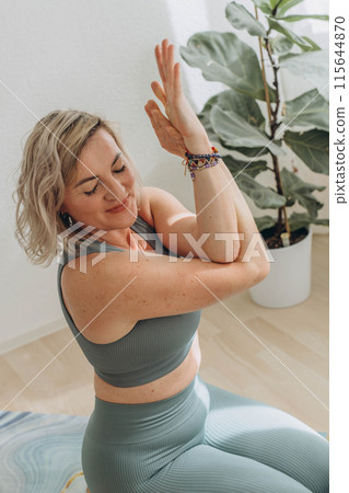 A 50-year-old woman does yoga at home A 50-year-old woman does yoga at home 115644870